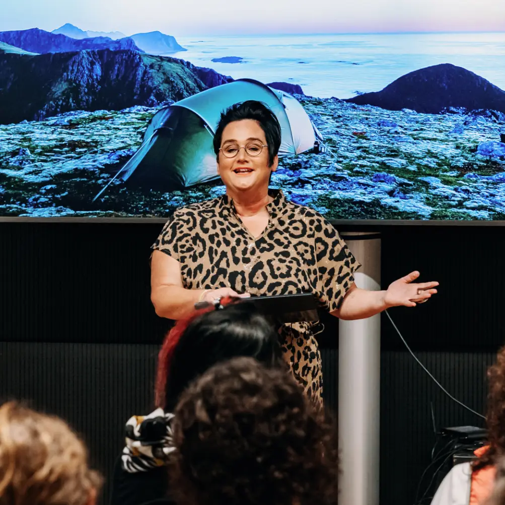 Frau hält Vortrag vor Publikum.