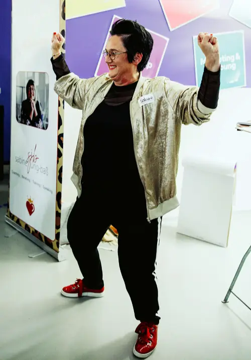 Speakerin Sabine motiviert ihre Zuhörerinnen mit einer Powerpose